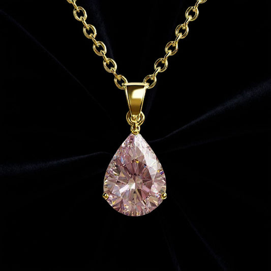 Guld halsband med droppformad rosa sten på svart sammetstyg i bakgrunden