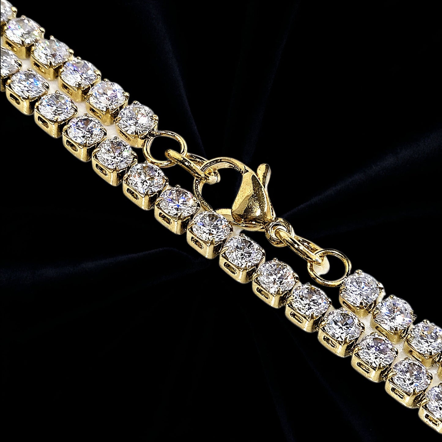 Guld halsband med ljusa stenar på svart sammet tyg i bakgrunden